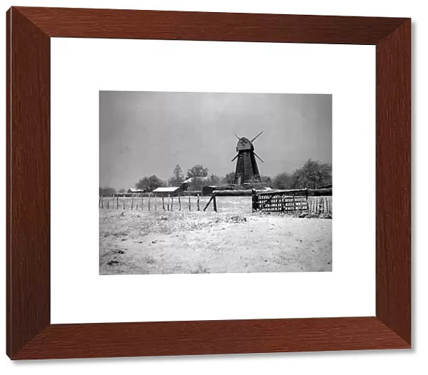 Windmill in white after early snow. Surrounded by a carpet of crisp powdery snow