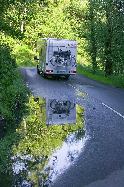 Reflections in a puddle on a road in the Trossachs Scotland UK