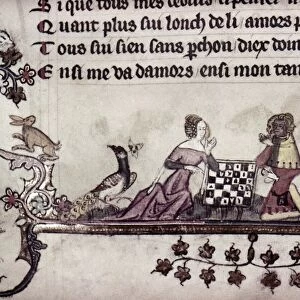 CHESS, 14th CENTURY. A game of chess. Beside the players sit two peacocks and a dog