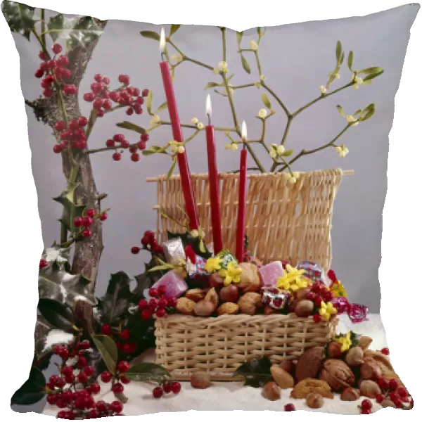 Christmas arrangement of candles, holly, mistletoe and nuts