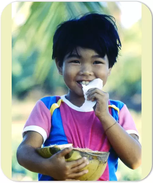 Little boy eating coconut, Thailand
