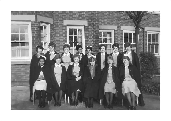 Black nurses amongst white nurses having a group picture