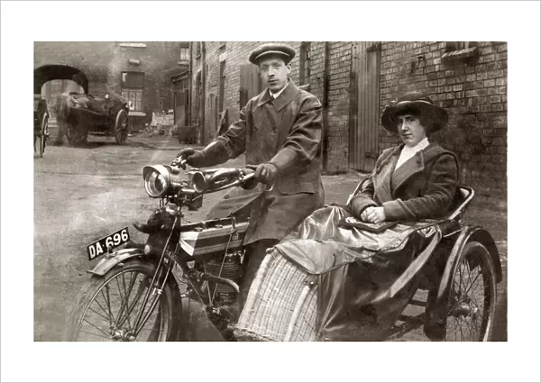 Lady & gentleman sitting on a 1910 Triumph motorcycle