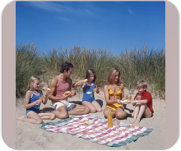 Family of five with picnic on beach
