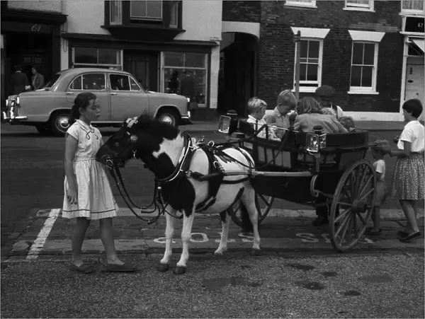 Pony giving a ride to children in his cart, Deal, Kent