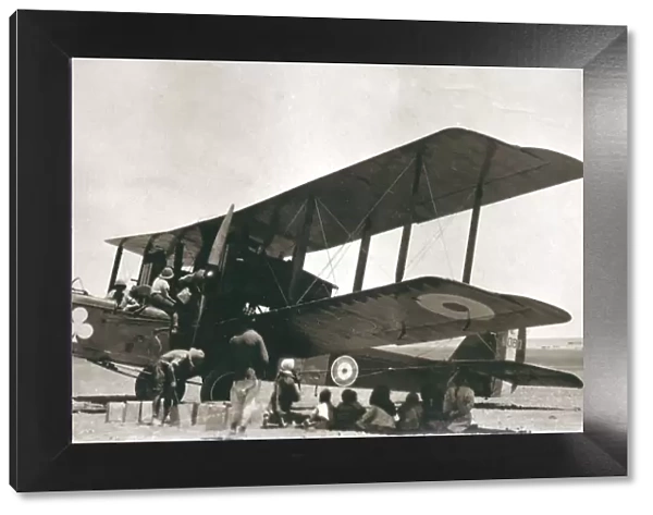 Biplane bomber with crew and arabs in the desert, Iraq
