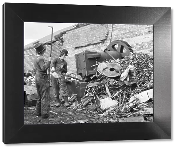 Two young men sorting through a pile of scrap metal