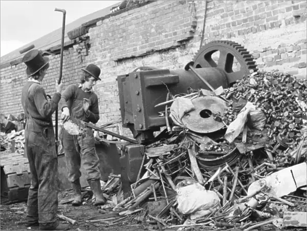Two young men sorting through a pile of scrap metal
