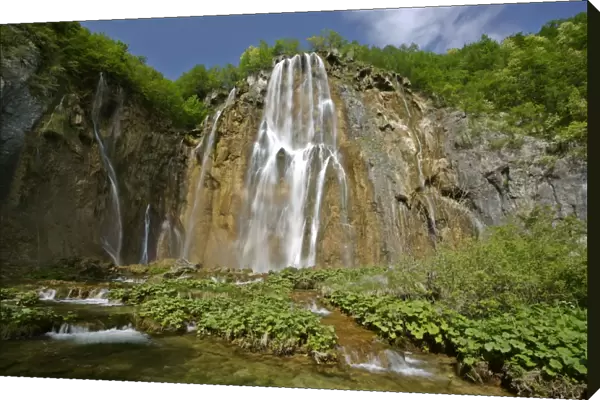 Waterfall cascading down steep cliffs in lower canyon area Plitvice Lakes National Park, Croatia