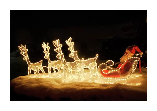 Christmas Decorations - illuminated reindeer & sleigh outside house. France