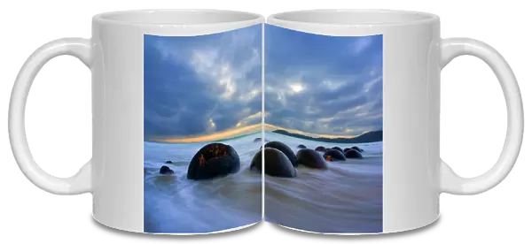 Moeraki Boulders - massive spherical rocks at dawn surrounded by water of incoming tide Coastal Otago, South Island, New Zealand