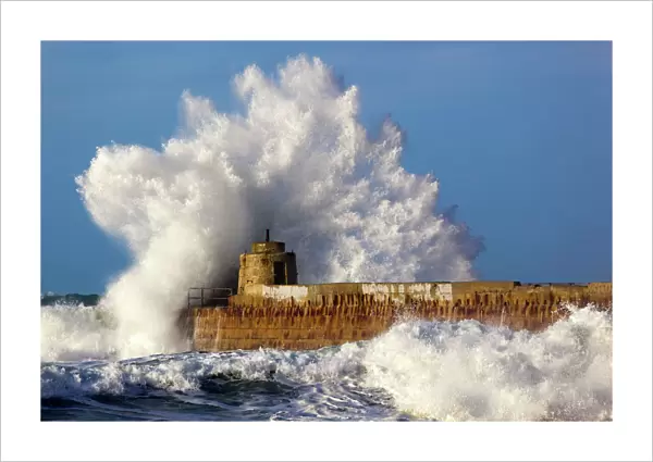 Portreath - wave breaks over pier in storm - Cornwall - UK
