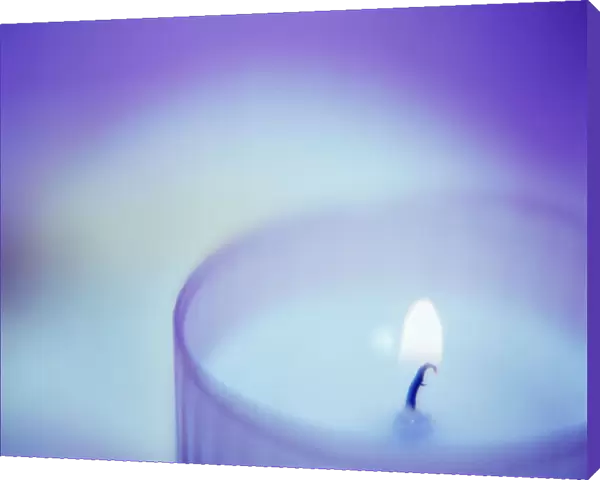 Candle burning in a glass container