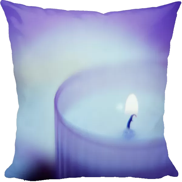 Candle burning in a glass container