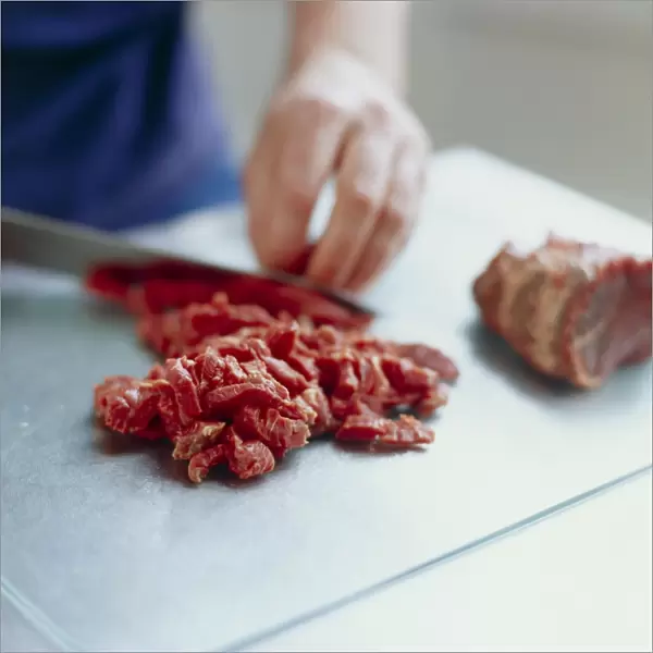 Red meat being prepared on a chopping board