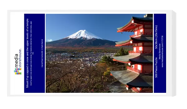 Mount Fuji capped in snow and the upper levels of a temple
