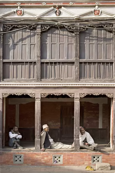 Three old men watch the world go by on a street in Bhaktapur