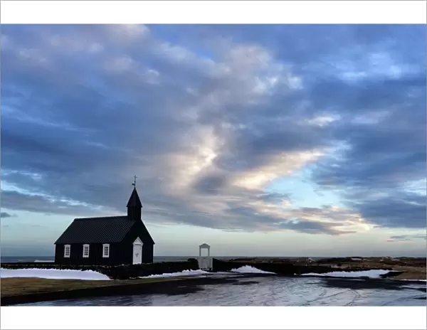 Winter view at dusk of black wooden church at Budir, Snaefellsnes Peninsula, Iceland