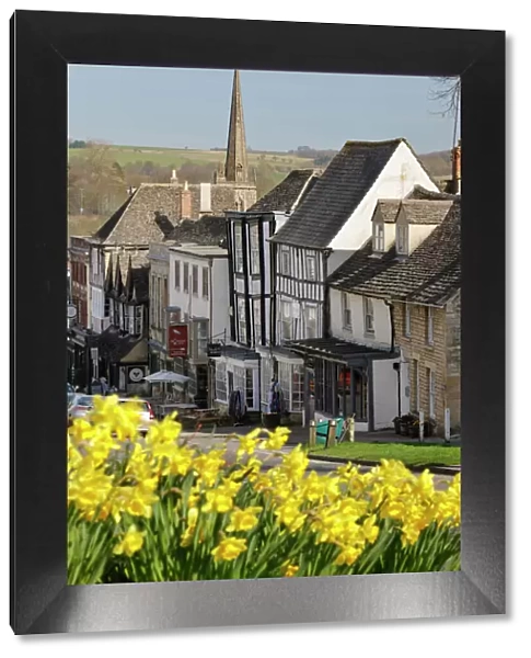 High Street and Burford Church with daffodils, Burford, Cotswolds, Oxfordshire, England