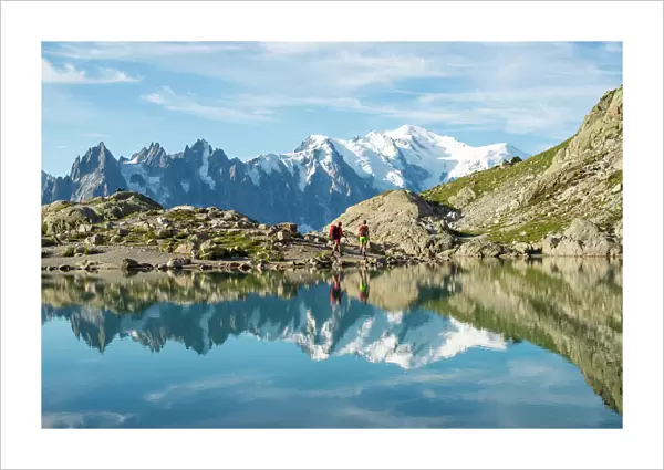 Hikers and the summit of Mont Blanc reflected in Lac Blanc on the Tour du Mont Blanc