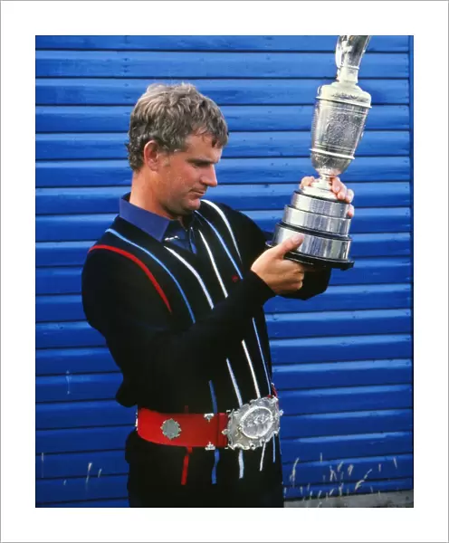 Sandy Lyle examines the Claret Jug while wearing a replica of the original Championship Belt in 1985