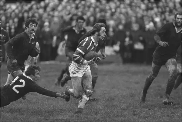 A bloodied JPR Williams runs for Bridgend against the All Blacks in 1978