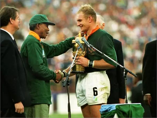 Francois Pienaar receives the Webb Ellis Cup from Nelson Mandela