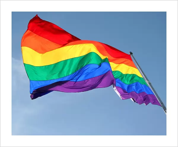Rainbow Flag flying against blue sky - Symbol of Gay Pride