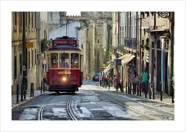 A tramway in Alfama district with the Motherchurch (Se Catedral) in the background