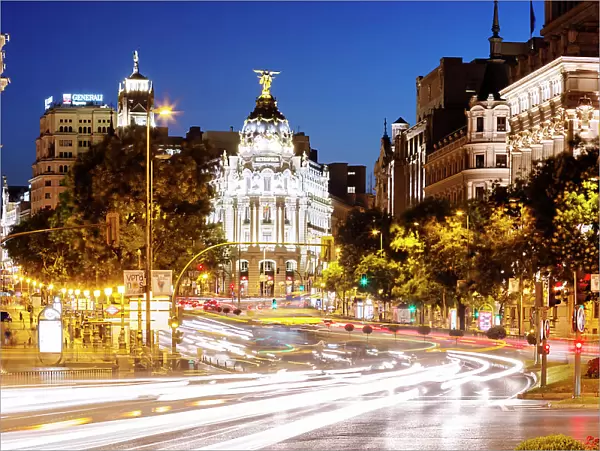 Spain, Madrid. Street view with Metropolis building and light trails
