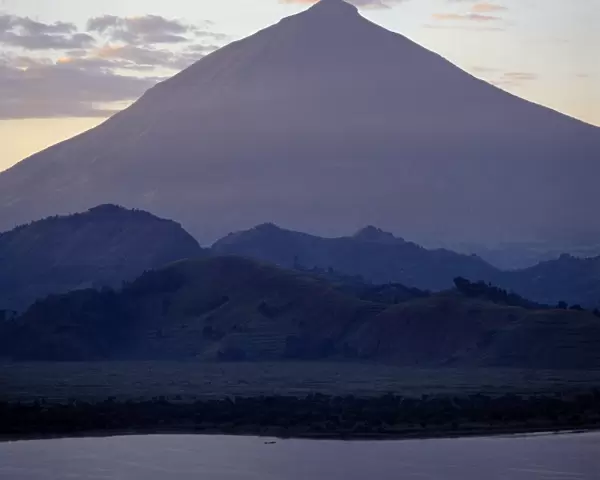 Photographed from Lake Mutanda at sunrise, Mount Muhavura looms like a huge pyramid