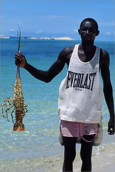 Fisherman with crayfish on the beach at Benguerra Island