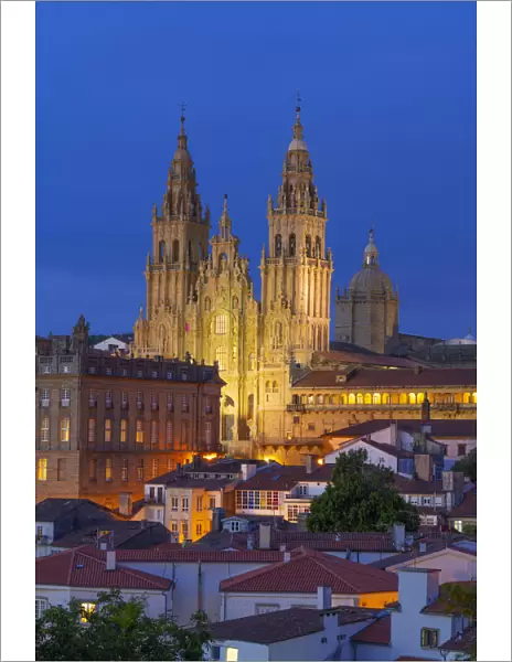 Spain, Galicia, Santiago de Compostela, view over rooftops to cathedral illuminated