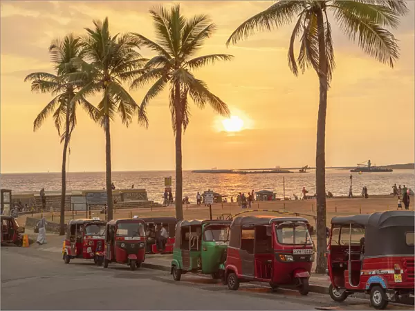 Tuk tuks parked along Galle Face Green at sunset, Colombo, Sri Lanka