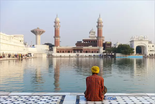 India, Punjab, Amritsar, Pilgrim sitting infront of The Harmandir Sahib, known as