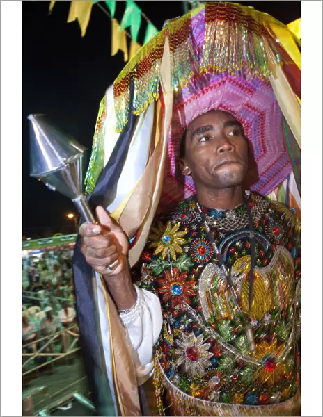 South America, Brazil, Maranhao, Sao Luis, a costumed dancer with a percussion instrument