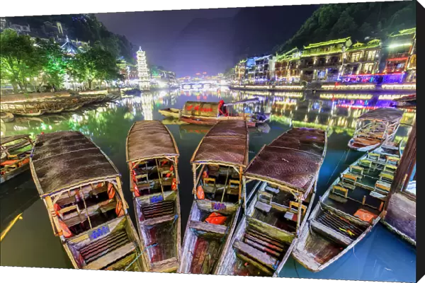 China, Hunan province, Fenghuang, traditional bamboo rafts and riverside houses reflecting