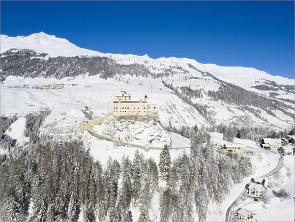 Aerial view of Tarasp castle after snowfall. Tarasp, Lower Engadine, Canton of Grisons