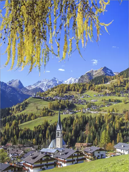 Yellow larches color the villages of Selva of Cadore and Saint Lucia hill in autumn