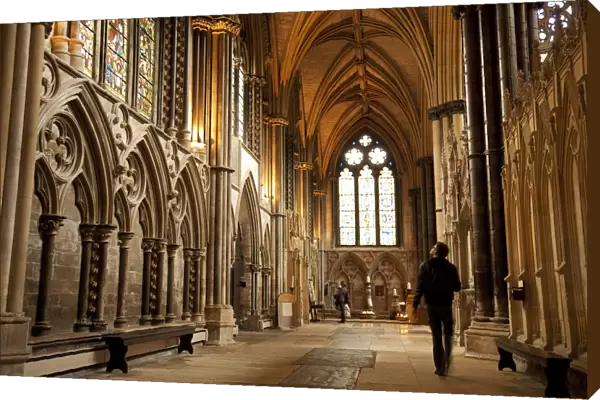 Lincoln, England. A visitor gazes at the medieval stained glass in Lincoln cathedral