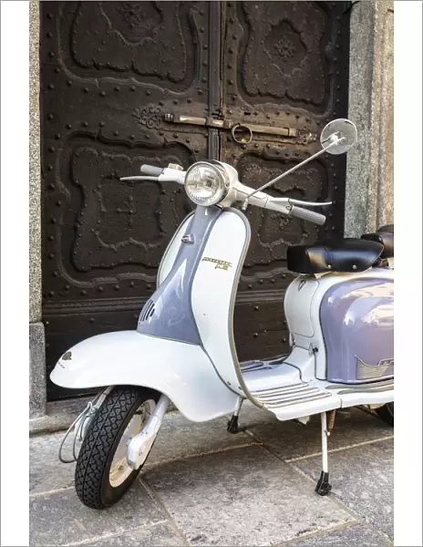 Bicolored Lambretta Innocenti scooter in front of ancient doorway, Morbegno, Sondrio
