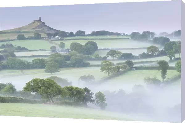 Rolling mist covered countryside surrounding Brentor Church, Dartmoor, Devon, England