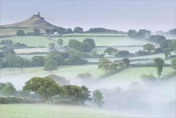 Rolling mist covered countryside surrounding Brentor Church, Dartmoor, Devon, England