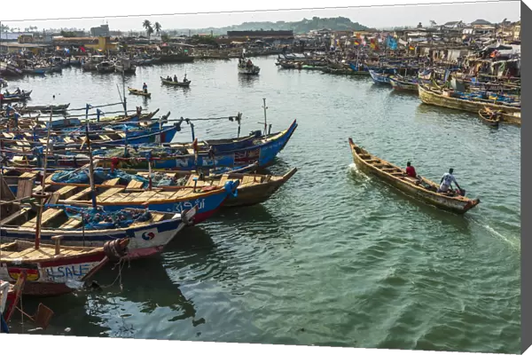 Africa, Ghana, Elmina harbour. Fishermen with their boats returning to the market