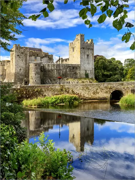 Europe, Ireland, Cahir castle and village at sunset reflecting in Caher river