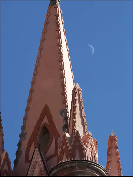 Mexico. A church steeple against a blue sky with the faint outline of the moon