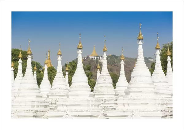 Mandalay, Myanmar. Kuthodaw pagodas spires with Mandalay hill on the background