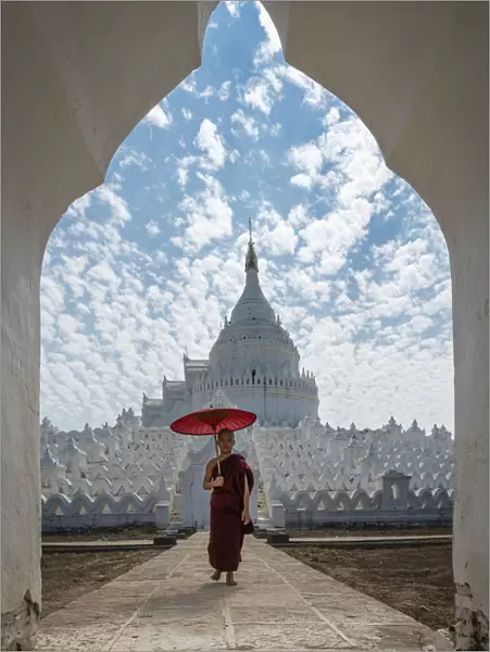 Novice monk walking with an umbrella at Hsinbyume pagoda, Mingun, Mandalay