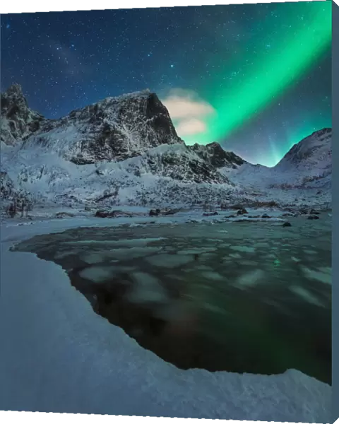 Northern lights over a partly frozen fjord during winter in the Lofoten islands, Norway