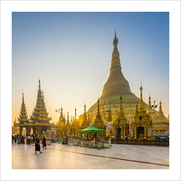 Tourists at golden Shwedagon Pagoda against clear sky at sunrise, Yangon, Yangon Region